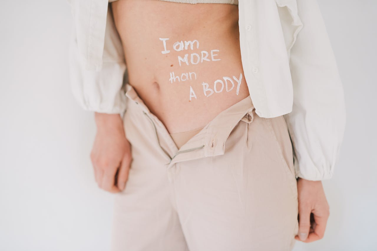 portfolio-06 Close-up of a woman with a feminist message on her body, promoting body positivity and empowerment.